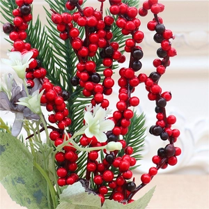 Close-up of artificial red berries and pine needles for Christmas decoration details