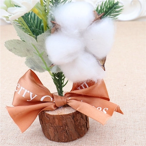 Close-up of a mini Christmas tree ornament with cotton, pine needles and wood base