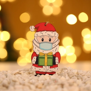 Wooden painted Santa ornament wearing a mask holding a gift box for Christmas tree decoration