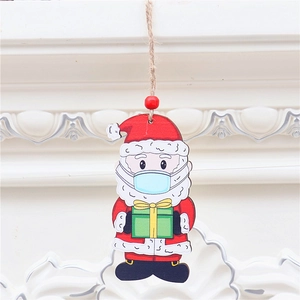 Wooden Santa Claus ornament wearing a blue mask hanging on white wall background