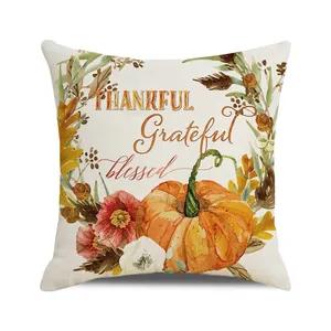 Detail of linen cushion cover showing watercolor orange pumpkin and autumn leaves