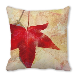 Detail view of cotton linen pillow cover featuring a large red maple leaf and autumn texture