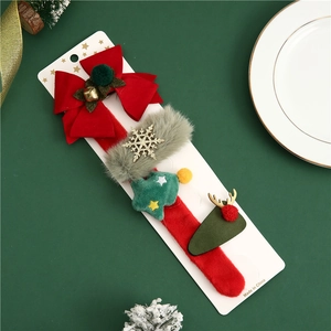 Detail of Christmas hair clip set with red bows and plush antlers on a festive display
