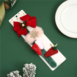 Macro shot of 4-piece Christmas hair clips featuring festive bows and reindeer on packaging