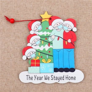 Macro view of wooden Christmas ornament with family and The Year We Stayed Home text