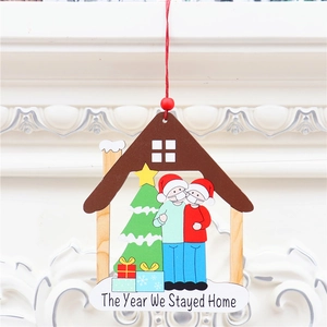 Adorno navideño de madera en forma de casa con figuras con máscara y arbolito