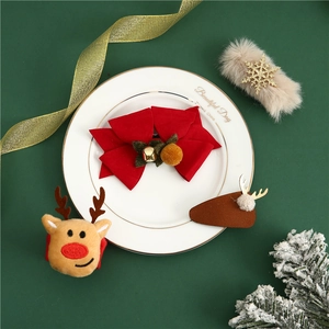Macro detail of Christmas hair clip set with velvet bows and elk antlers on festive plate