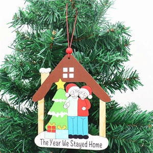 Adorno de madera con Papá Noel con máscara y texto The Year We Stayed Home en árbol