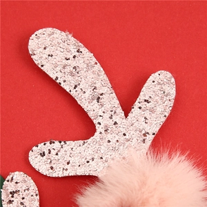 Detail van roze pailletten gewei en zachte pluche pompon op een kerst hoofdband