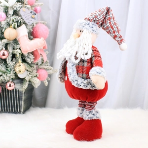 Dettaglio del Babbo Natale di peluche con barba lunga e cappello a maglia in set festivo