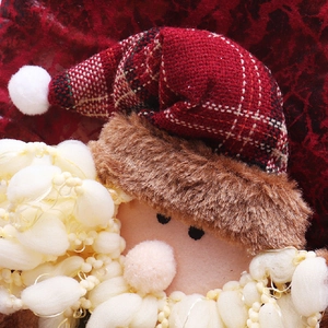 Close-up of Santa Claus plush doll featuring white loop yarn beard and plaid hat detail