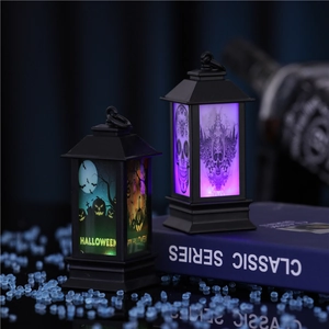 Detail of Halloween LED lanterns with pumpkin and skull designs on a classic book
