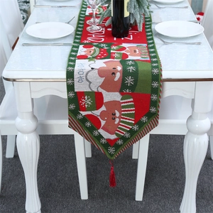 Detail eines gestrickten Weihnachts-Tischläufers mit Weihnachtsmann und roten Quasten