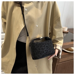 Detail of leopard print crossbody bag with gold twist lock and velvet texture finish