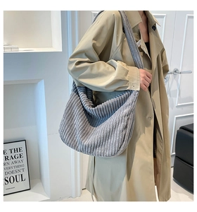 Texture detail of grey corduroy hobo bag shown in a lifestyle minimalist setting