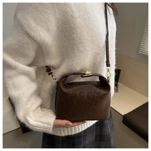 Détail du mini sac seau à imprimé léopard avec détails dorés et bandoulière