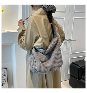 Détail de la texture du sac hobo en velours côtelé gris avec rayures sur la bandoulière