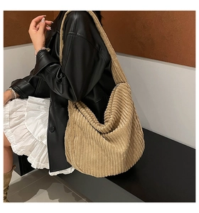 Khaki corduroy tote bag shown on shoulder with wide strap and vertical stripe texture