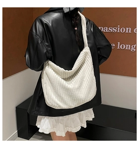 Texture détaillée du sac à bandoulière en velours côtelé blanc porté par un mannequin