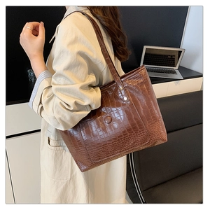 Detail of vintage brown crocodile embossed large tote bag with a small snap pocket