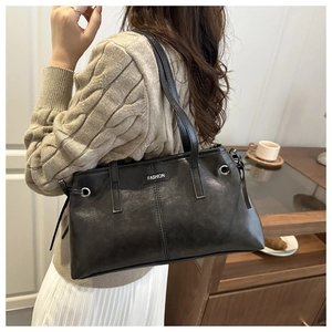 Detail of black leather tote bag with FASHION label on a cozy urban model background