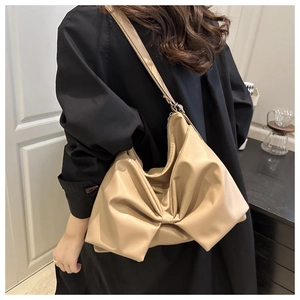 Detailed view of apricot bow shoulder bag showing PU leather texture and zip closure
