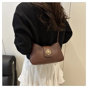 Detalle de bolso bandolera marrón vintage con cierre de hebilla metálica dorada de flores
