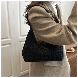 Detail of hobo leopard print shoulder bag styled with a wool coat for autumn winter