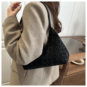 Detail shot of black leopard print hobo bag with sleek texture and slim shoulder strap