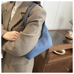 Detail of blue leopard print matte shoulder bag on brown wool blazer for daily style