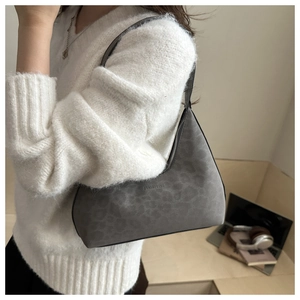 Detail of grey leopard print suede hobo bag with zip closure and adjustable shoulder strap