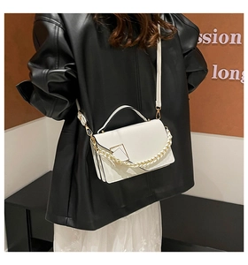 Detail of off-white crossbody bag with metal buckle and stylish dual chain strap