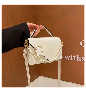 Detalle del bolso de cuero PU blanco crema con hebilla geométrica dorada y cadena tejida