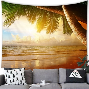 Tropical sunset beach tapestry with palm leaves hanging above a sofa in a modern room