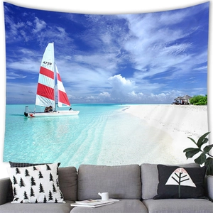 Detail of tropical beach wall tapestry featuring a sailboat over a grey sofa in a living room