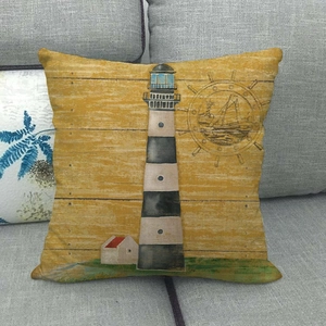 Detailed close-up of a nautical lighthouse linen pillow cover on a grey sofa background