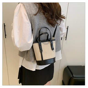 Rear view of minimalist contrast canvas bucket bag with black leather trim and top handle