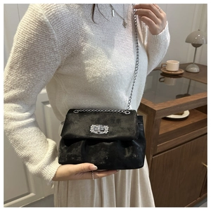 Détail du sac bandoulière noir avec boucle en strass et bandoulière chaîne argent