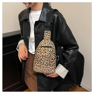 Detail view of leopard print crossbody bag with adjustable strap and dual zipper pockets