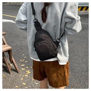 Vue extérieure d'un sac bandoulière noir en nylon avec double zip et sangle réglable
