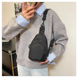 Vue détaillée du sac bandoulière en nylon noir imperméable avec sangle réglable et zip