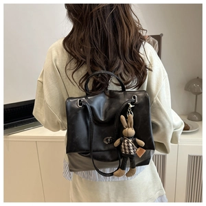 Detail of black PU leather tote backpack with metal twist lock and cute bunny charm