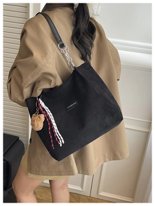 Détail du sac cabas noir avec étiquette en cuir Creative Cat et breloque ours en peluche