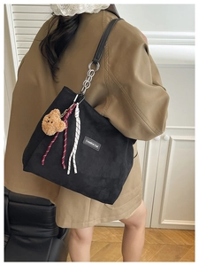 Détail du sac cabas en velours noir avec bandoulière chaîne et breloque ourson
