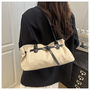 Detail der beigen Wildleder-Tote-Bag mit schwarzem Lederriemen und Vintage-Schnallendesign