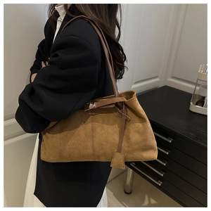Gros plan sur le sac cabas en daim marron avec fines lanières et détail de boucle