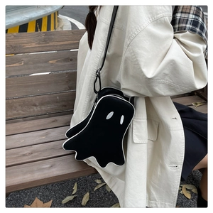 Detail of creative ghost-shaped crossbody bag with white piping and eye embroidery