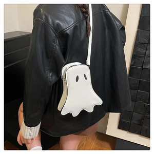 Detail of white ghost crossbody bag with black eyes and adjustable strap on a leather jacket