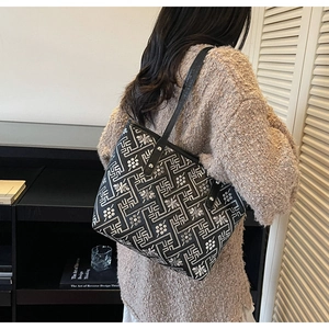 Detailed close-up of a geometric pattern tote bag worn by a model in a modern interior