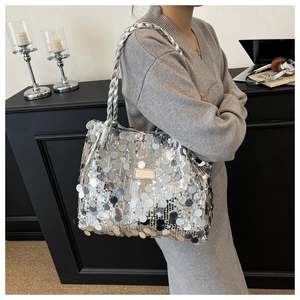 Silver sequin tote bag with woven strap shown on a model in a trendy party style